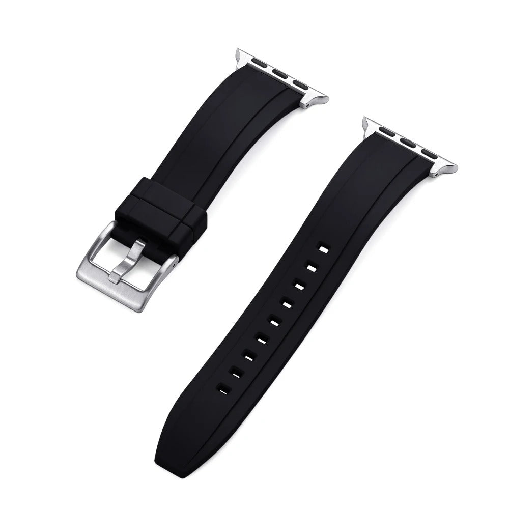 Close-up of a black rubber Apple Watch strap with a silver buckle and adapter, shown detached into two pieces on a white background.