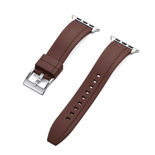 Close-up of a brown rubber Apple Watch strap with a silver buckle and adapter, shown detached into two pieces on a white background.