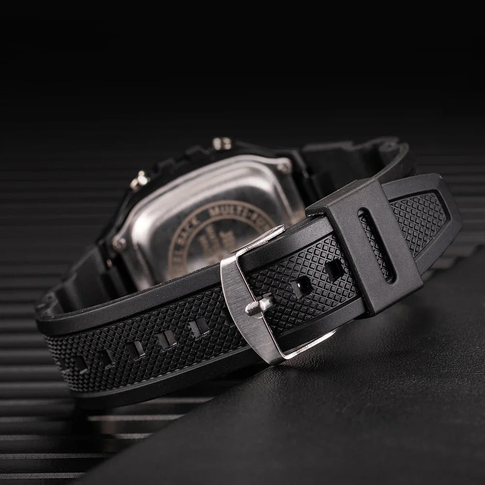 Rear view of a black digital watch with stainless steel case back and adjustable rubber strap with pin buckle.