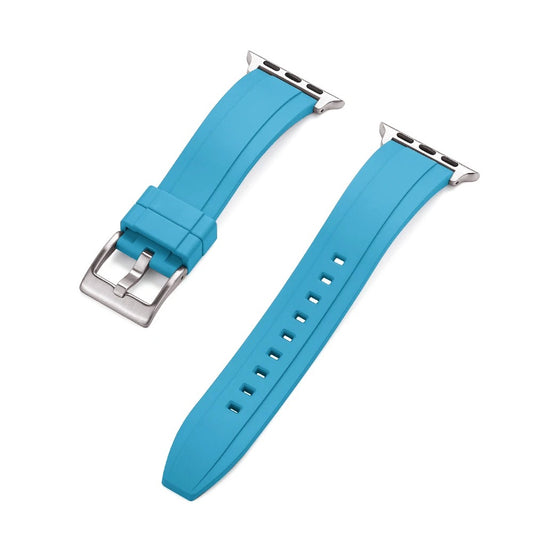 Close-up of a light blue rubber Apple Watch strap with a silver buckle and adapter, shown detached into two pieces on a white background.