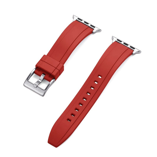 Close-up of a red rubber Apple Watch strap with a silver buckle and adapter, shown detached into two pieces on a white background.