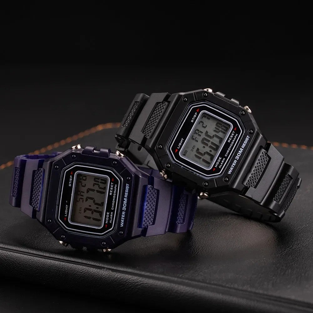 Dark blue and black digital watch lying on the notebook showing time, date and alarm clock