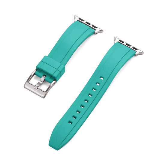 Close-up of a turquoise rubber Apple Watch strap with a silver buckle and adapter, shown detached into two pieces on a white background.